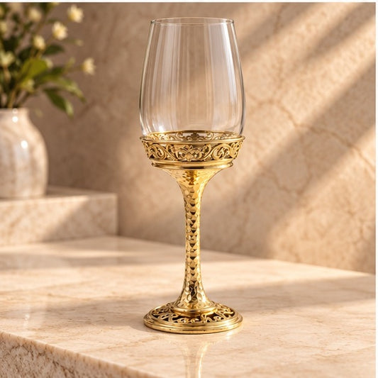 Wine glass with a gold electroformed base and filigree collar, on a marble counter