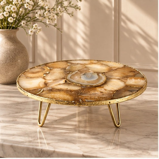 Golden brown agate cake stand with a pale geode centre and gold hairpin legs, on marble