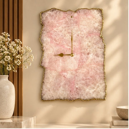 Large rose quartz agate wall clock, soft pink stone with a gold organic edge, above a console