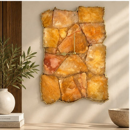 Golden brown agate wall clock on a warm wall beside a plant and a wooden bowl