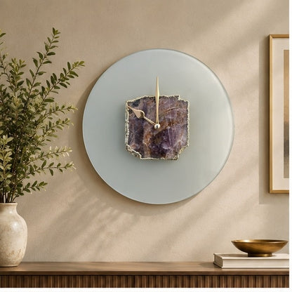 Frosted glass wall clock with a purple amethyst slab at its centre, above a console