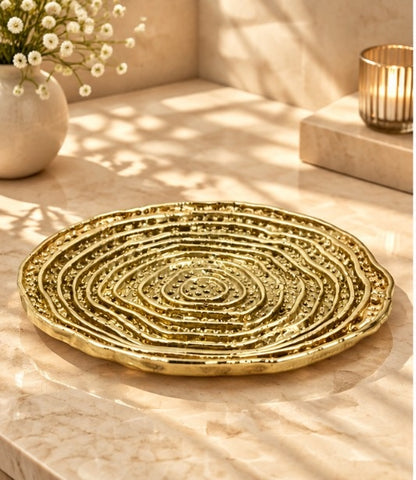 Spiral dosa tray in the gold finish beside candles