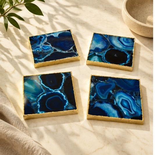 Four blue agate square coasters with gold electroformed edges on cream linen