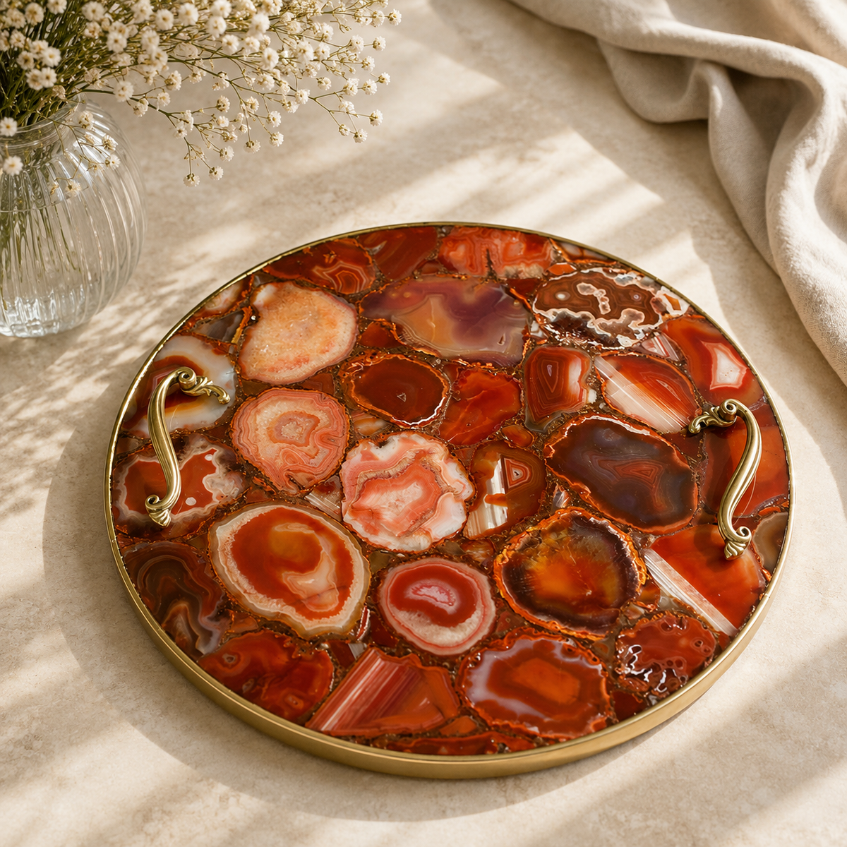 Red agate round tray with ornate brass handles, rose gold finish