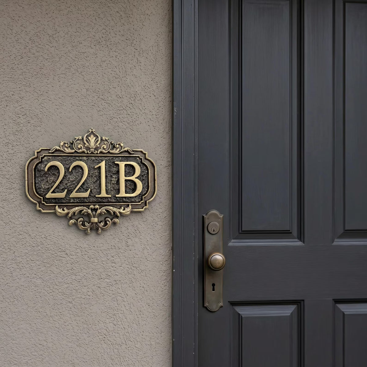 Antique brass crest house number plate mounted beside a dark panelled front door