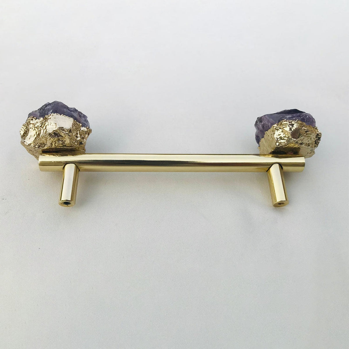 Gold rod on two posts, violet crystal chunks in gold at both ends