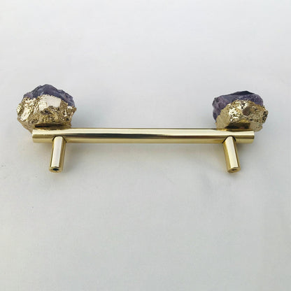 Gold rod on two posts, violet crystal chunks in gold at both ends