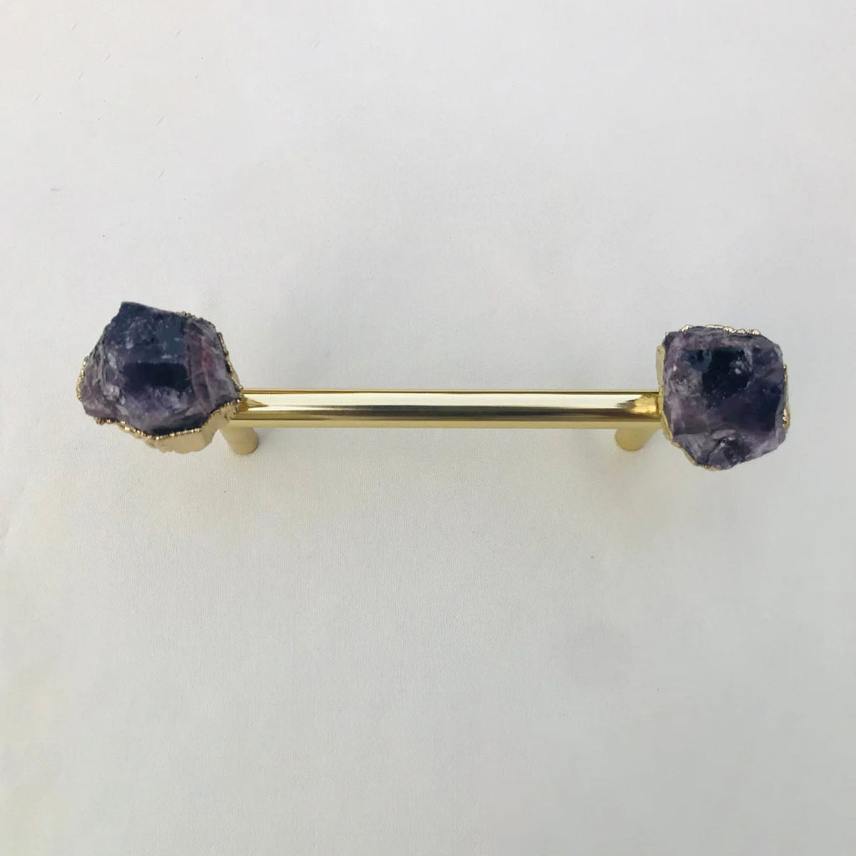 Gold bar pull straight on, deep purple crystal ends on a white ground