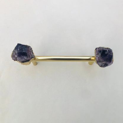 Gold bar pull straight on, deep purple crystal ends on a white ground