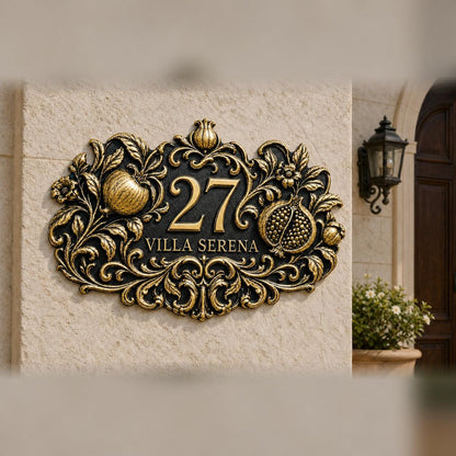 Pomegranate plaque in antique brass, pictured on a wall