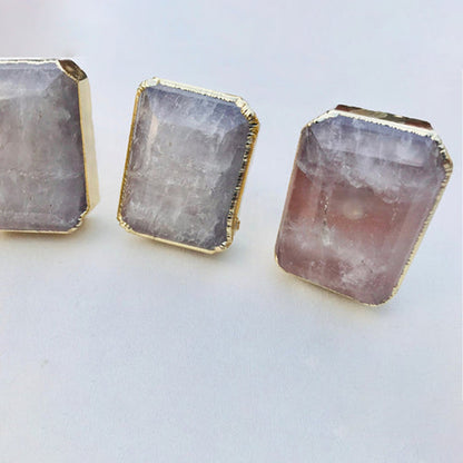 Three large quartz knobs, milky grey and pink faces side by side