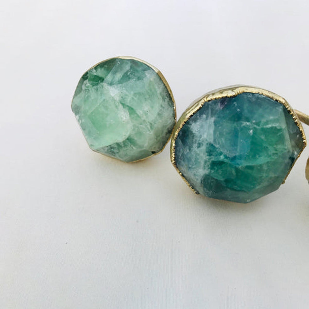 Two large faceted knobs, one pale green and one banded blue green