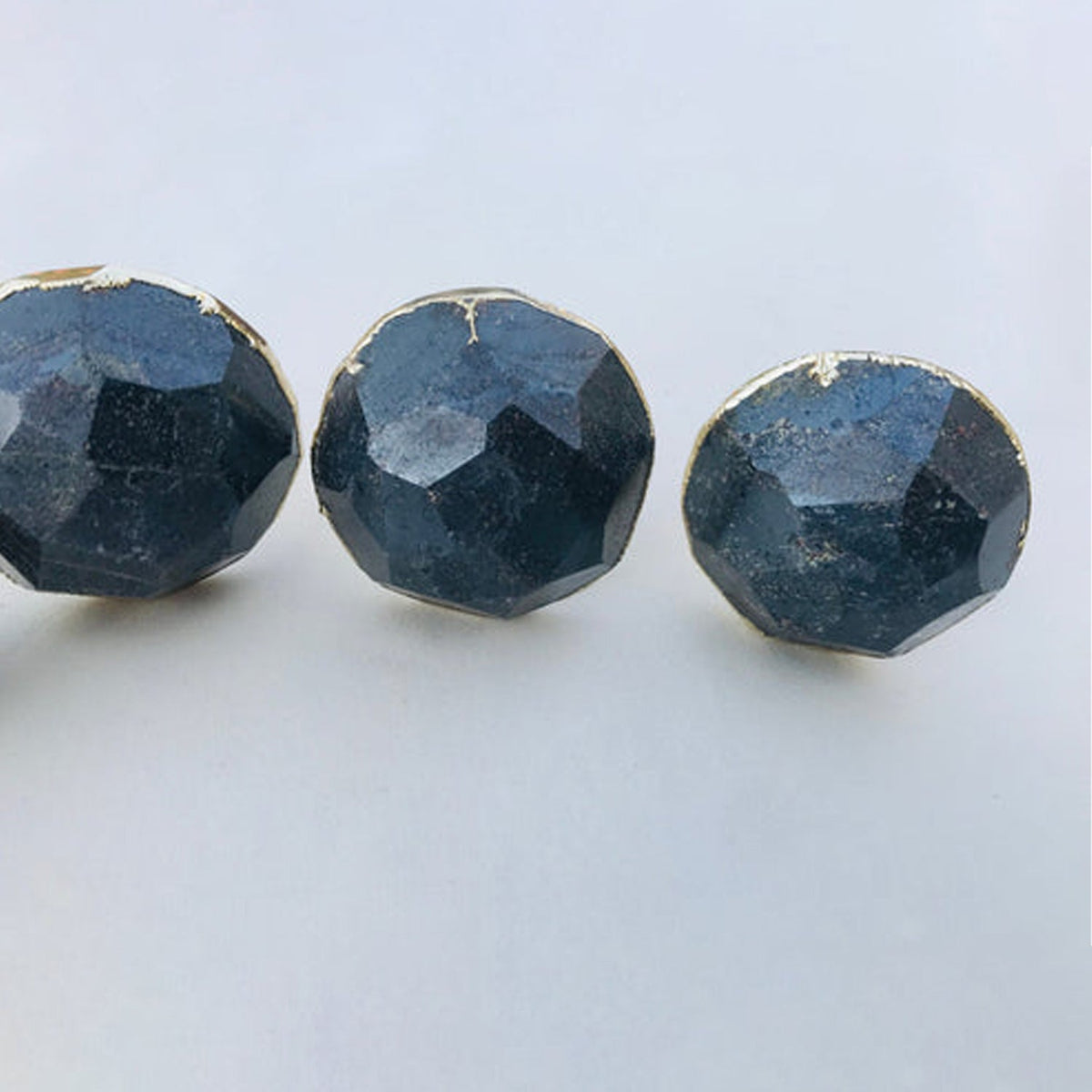 Three round knobs close, steel grey hematite with a metallic sheen