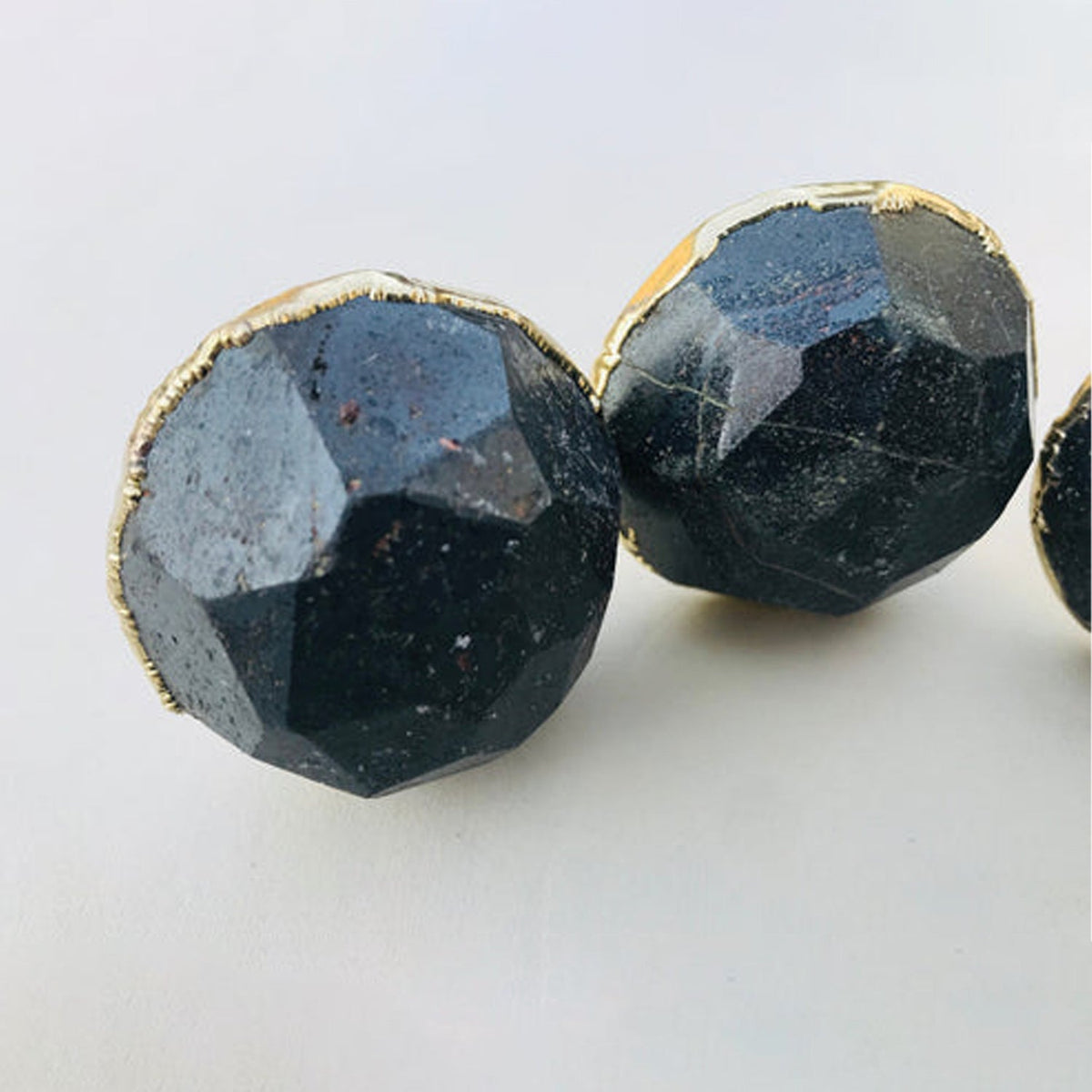 Two large round hematite knobs, grey blue facets catching the light