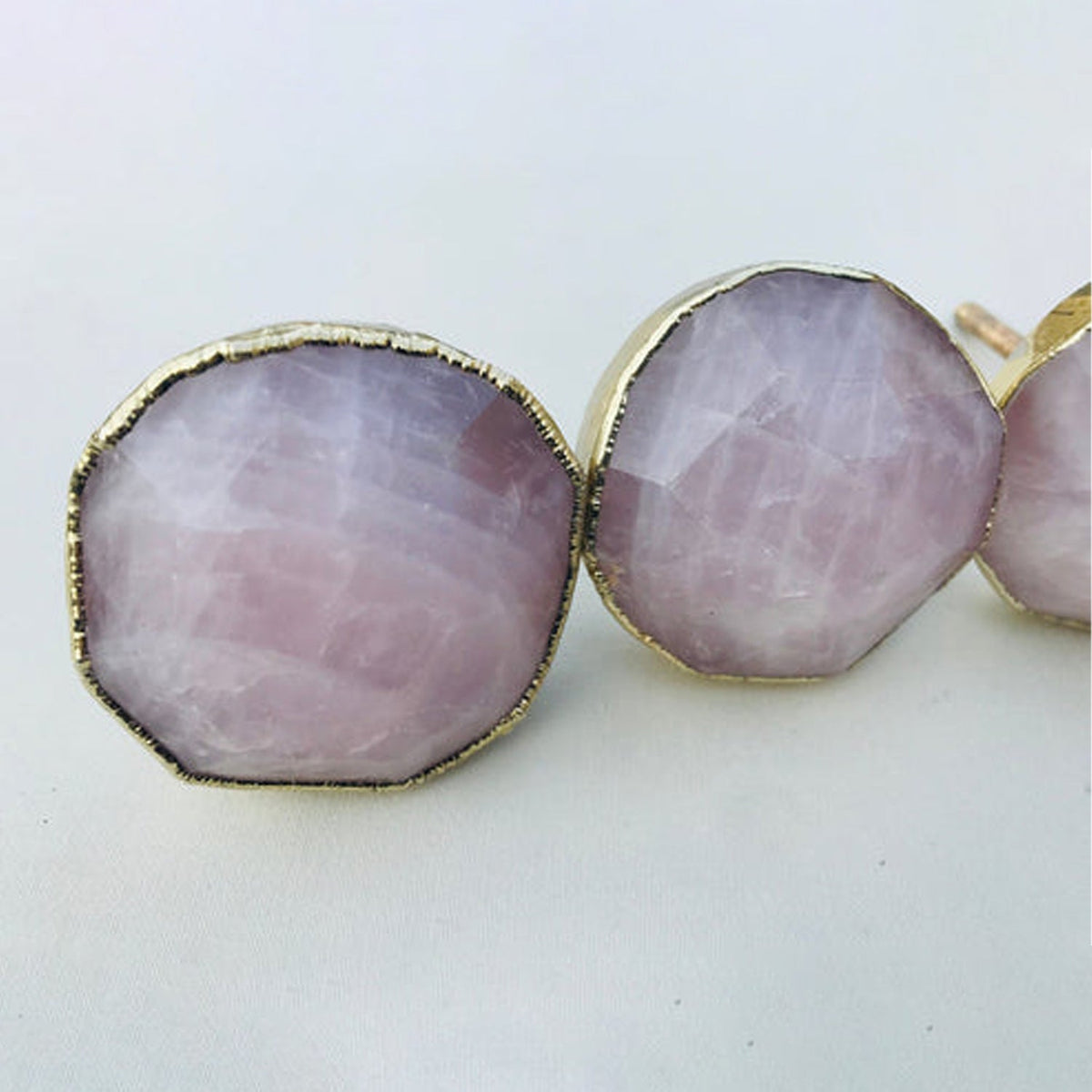 Three large round knobs, pale mauve facets catching the light