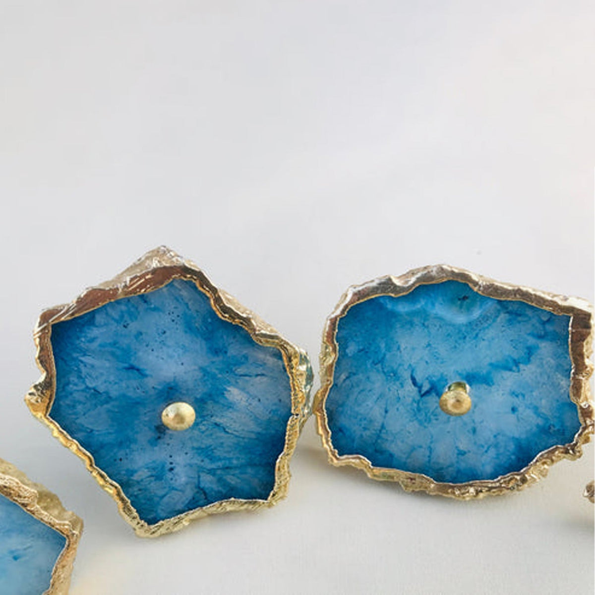 Two slices seen from above, cobalt agate with pale centres and brass screws