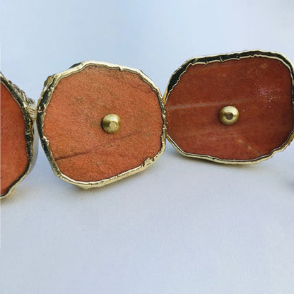 Two large slices close, deep terracotta stone with a fine gold border