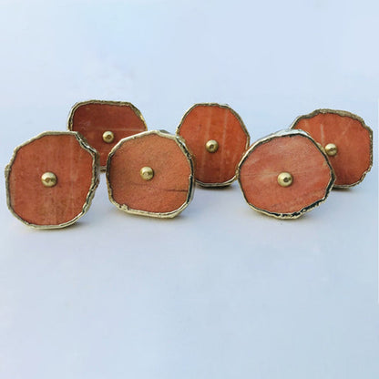 Six round slices in a curve on white, burnt orange stone in gold rims