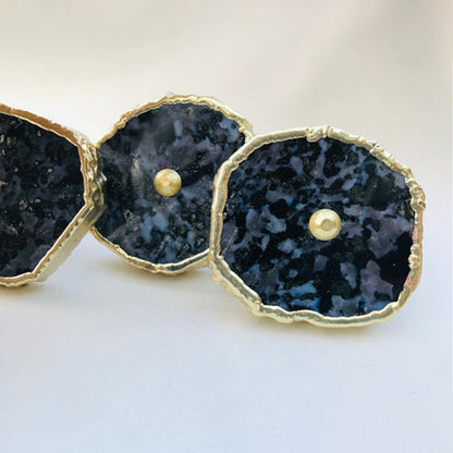 Three gabro slices in a row, dark blue black faces flecked with pale grey