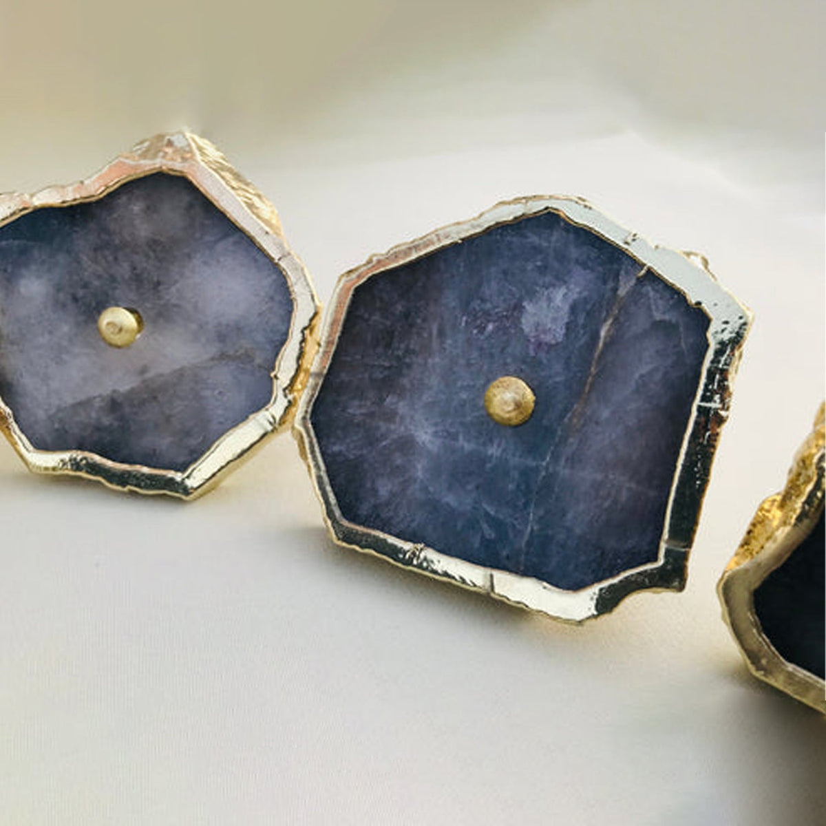 Two large grey slices close, blue grey stone inside crusted gold rims
