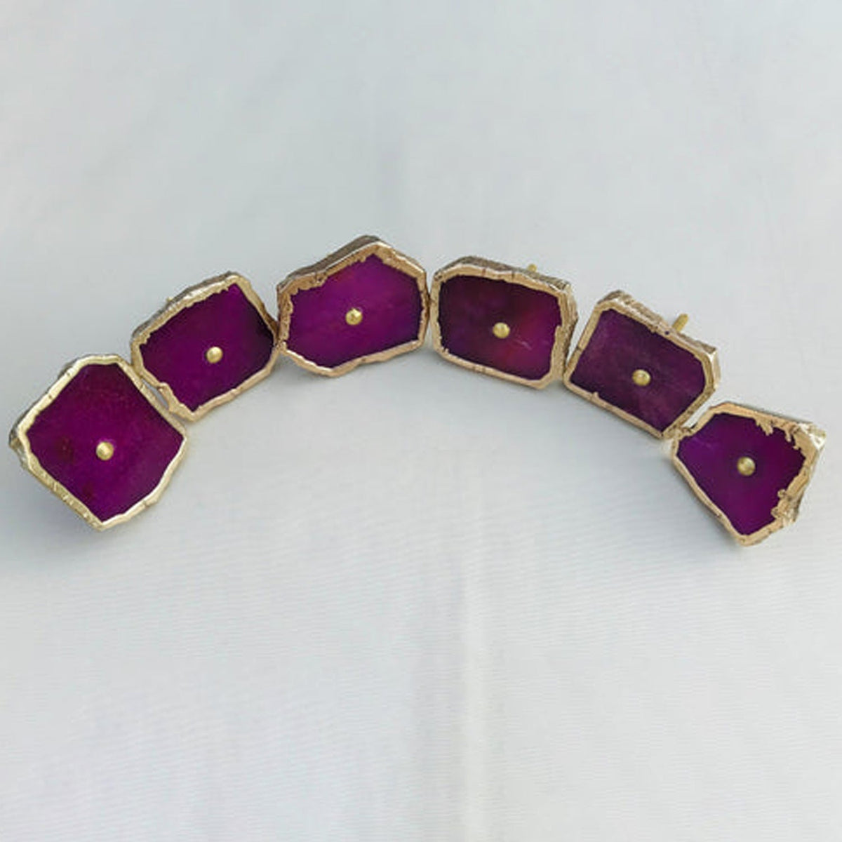 Six magenta slices arranged in an arc on white, brass centre screws