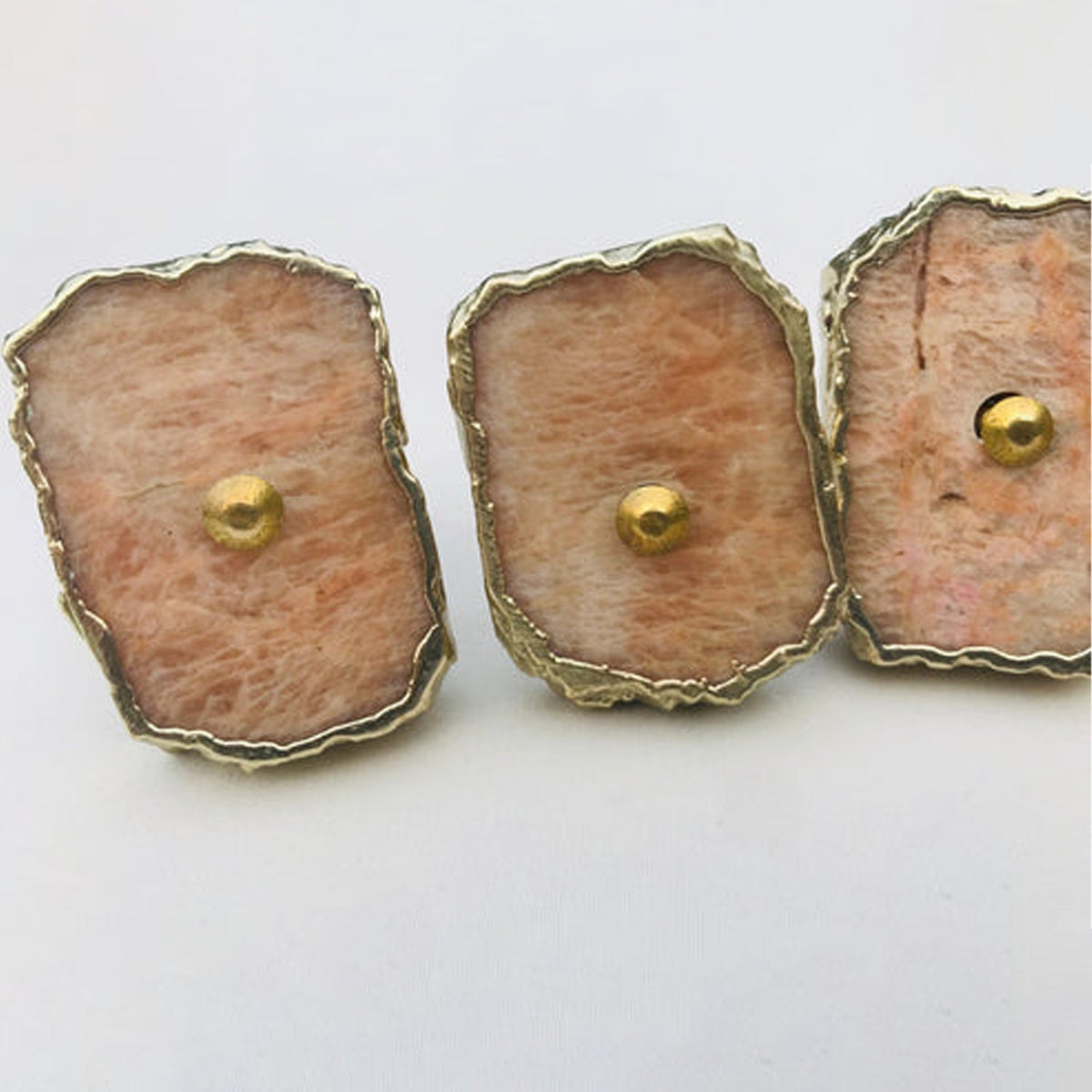 Three slices in a row, pale peach stone streaked with cream and grey