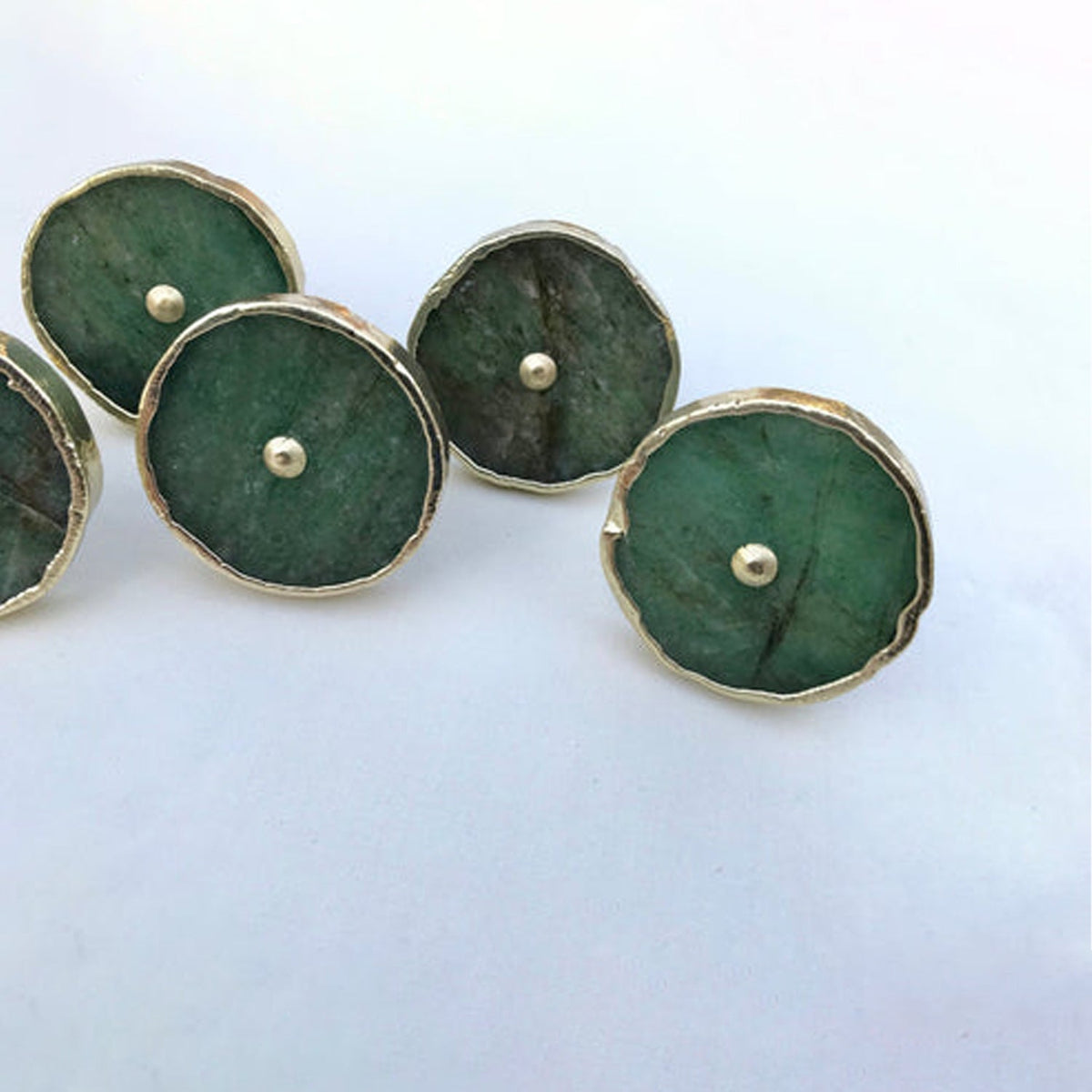 Four discs clustered, deep forest green stone under thin silver edging