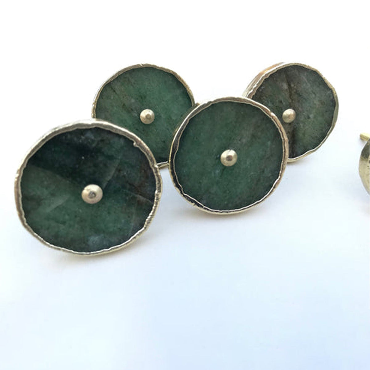 Four round green stone knobs on white, silver rimmed with silver centres