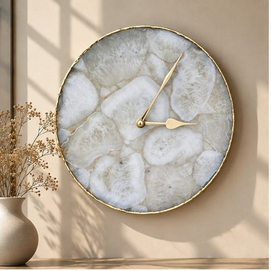 Large white crystal agate circular wall clock with a gold rim, above dried stems