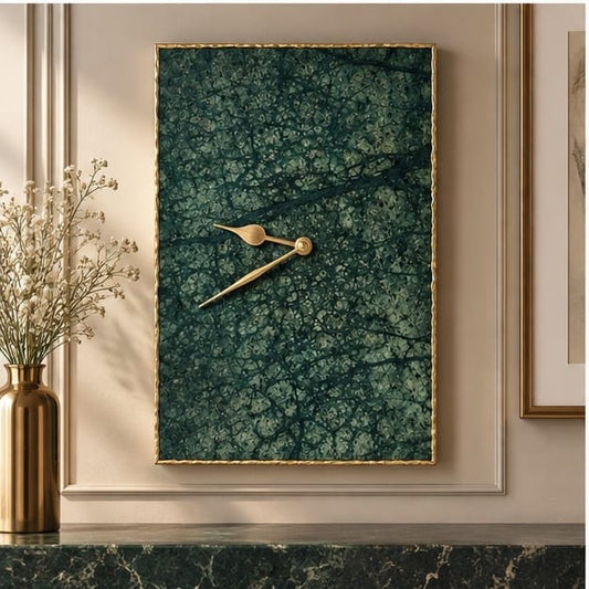 Large green marble rectangular wall clock in a gold frame, on a panelled wall above a mantel