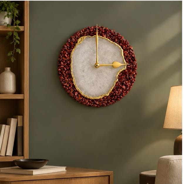 Burnt red crystal agate wall clock on a dark green wall beside a bookshelf and lamp