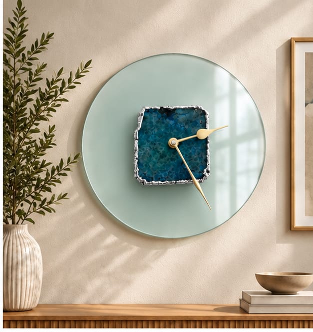 Glass agate wall clock in the gold finish, hung beside a framed print