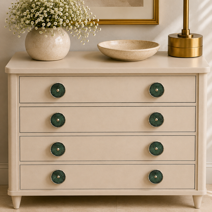 Eight dark green disc knobs across four drawers of a cream chest