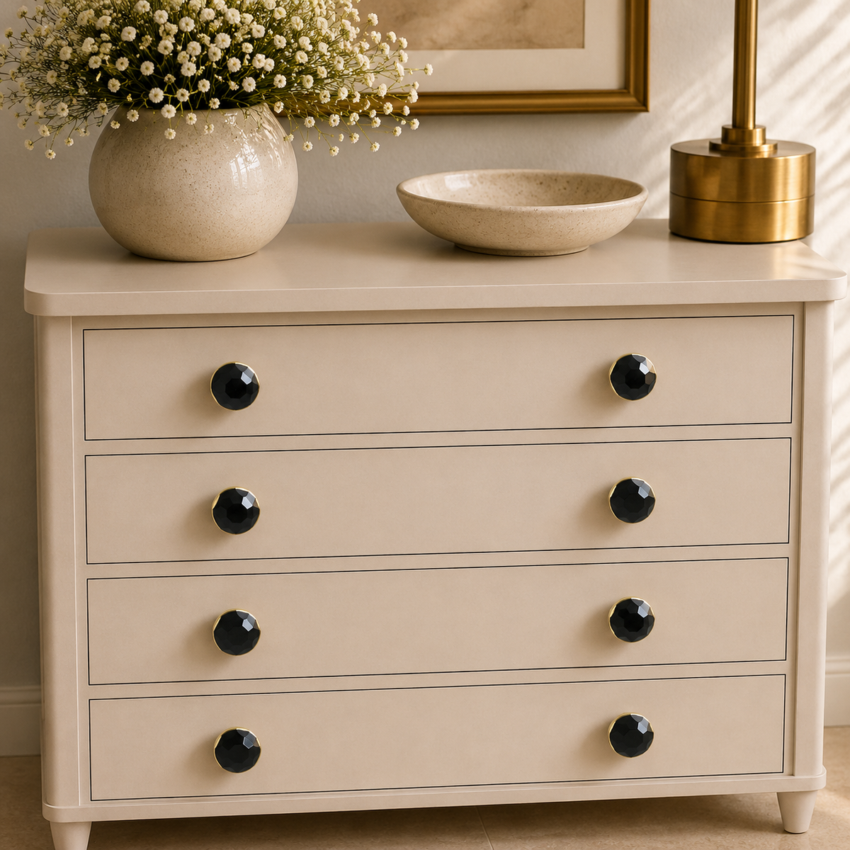 Eight small hematite knobs across four drawers of a cream chest of drawers