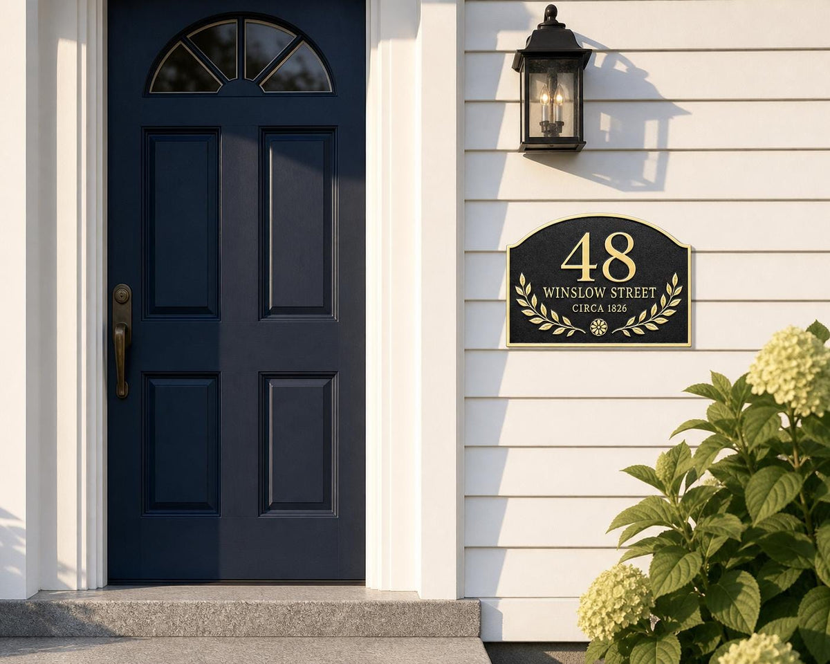 Arched Laurel name plate pictured beside a blue entrance door and porch lantern