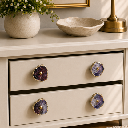 Four amethyst slice knobs on a cream chest, mirror and brass lamp behind